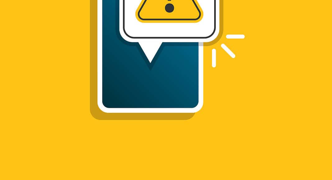 Smartphone che mostra un segnale di avvertimento giallo con un punto esclamativo in un fumetto su sfondo giallo, simile a un avviso di WhatsApp.