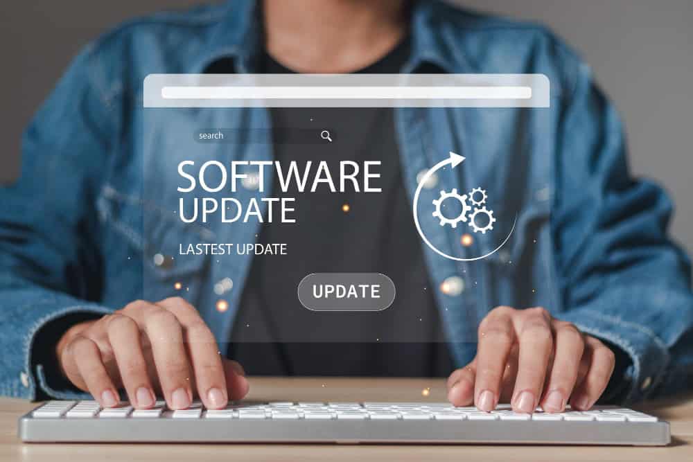 Una persona digita su una tastiera con un'interfaccia olografica "Aggiornamento software" visualizzata sopra, gestendo senza problemi un aggiornamento sito web.