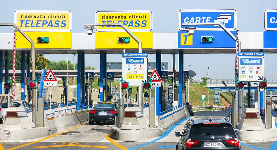 Le auto che entrano in un casello autostradale italiano percorrono le corsie Telepass con la loro caratteristica segnaletica orizzontale blu, semplificando notevolmente il viaggio.