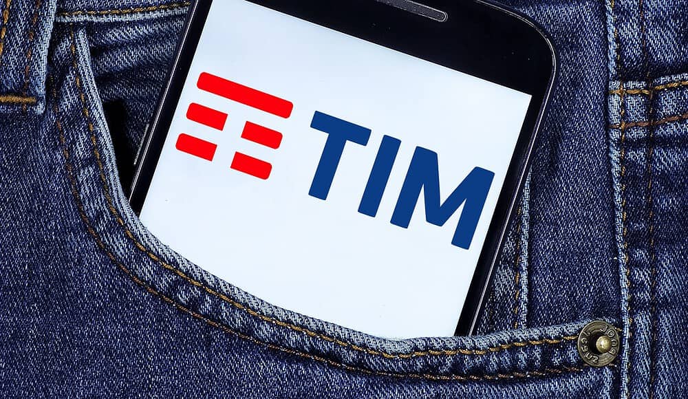 Uno smartphone con il logo TIM fa capolino con stile dalla tasca anteriore di un paio di jeans blu sbiaditi.